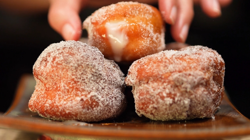 Three Sugar-Coated Hawaiian-Style Malasadas on A Plate