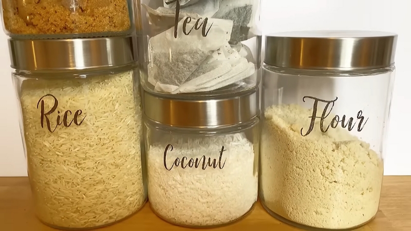 Glass jars filled with rice, coconut, tea, and flour feature clear transparent labels