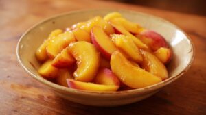 Close-up of a bowl filled with sliced fresh peaches for a galette filling