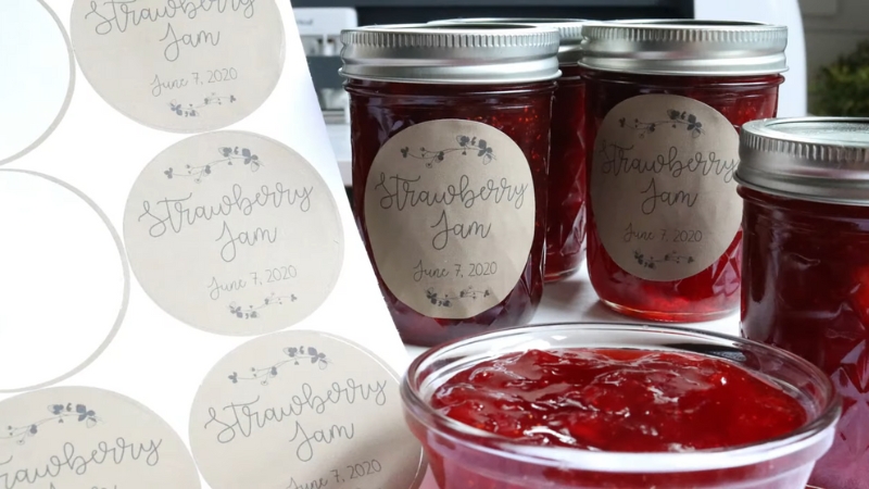 Strawberry jam jars are labeled with round pre-cut stickers