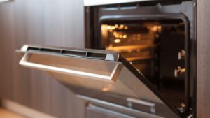 An open oven preheating with the door slightly ajar