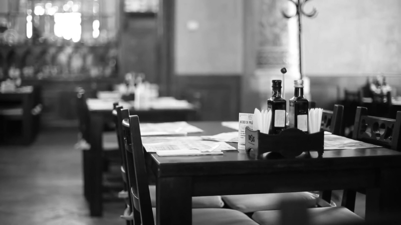 Interior of Hanul Berarilor restaurant in Bucharest with wooden tables set for guests