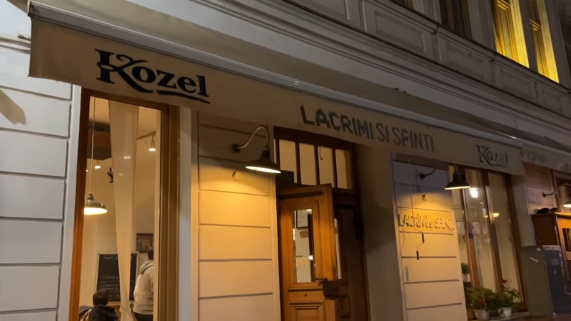 Front entrance of Lacrimi și Sfinți restaurant in Bucharest at night with lit windows and signage