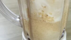A creamy date and walnut mixture blending in a blender